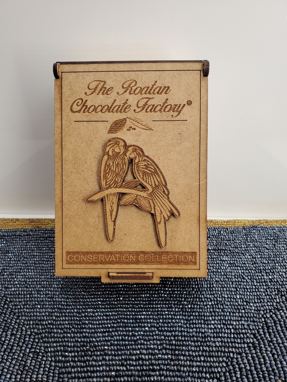 The Roatán Chocolate Factory wooden box featuring laser-engraved  of two macaws
